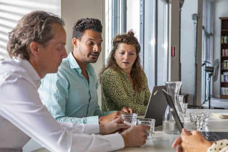 3 collega's overleggen aan tafel