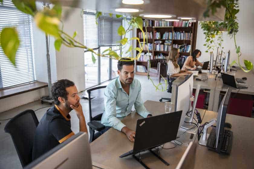 Twee collega's werken samen achter de computer