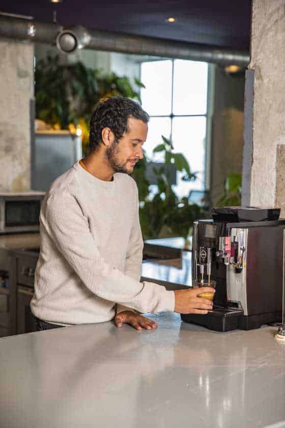 Collega bij koffie apparaat