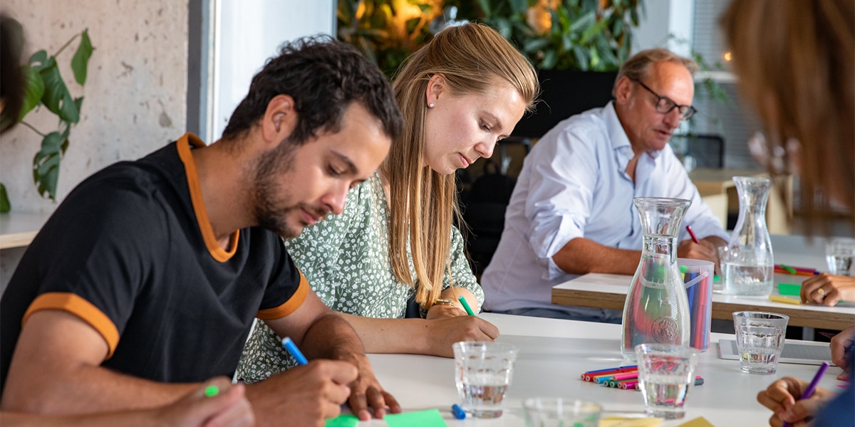 mensen schrijvend aan tafel