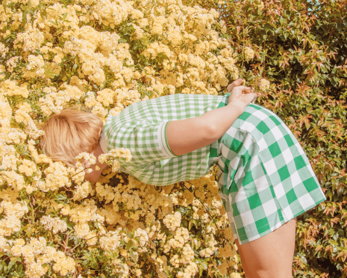 Nieuwsgierige dame ruikt aan bloemen